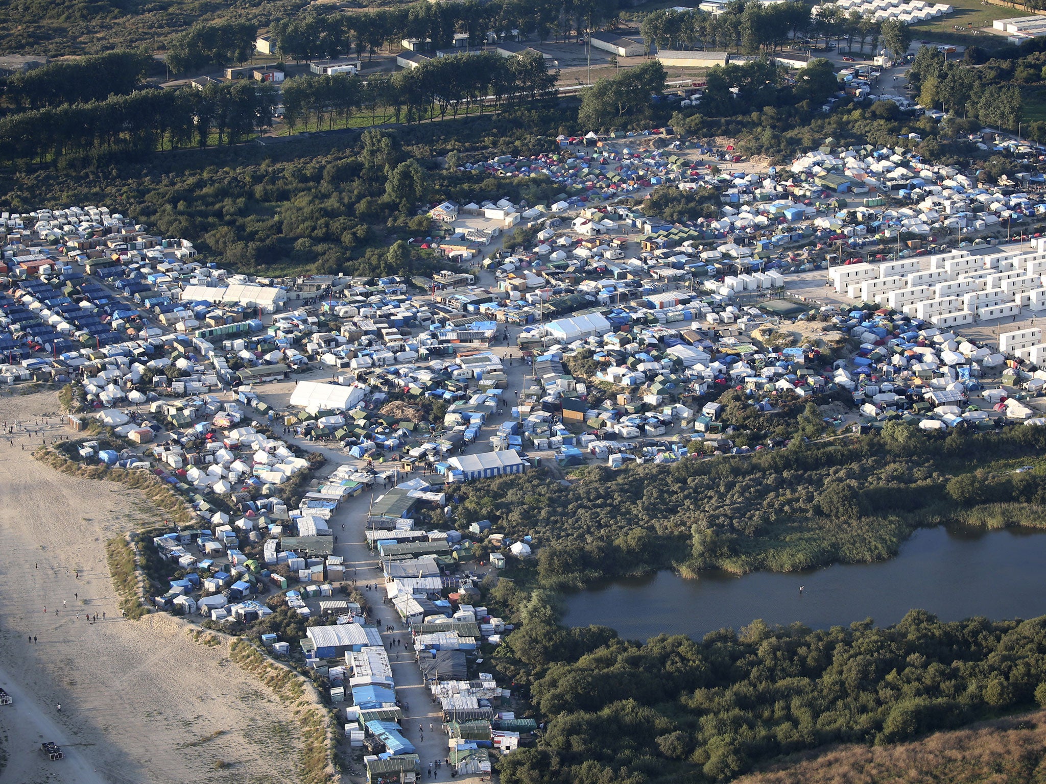 An aerial view shows makeshift shelters, tents and containers where migrants live in what is known as the Jungle, a sprawling camp in Calais, France, September 7, 2016