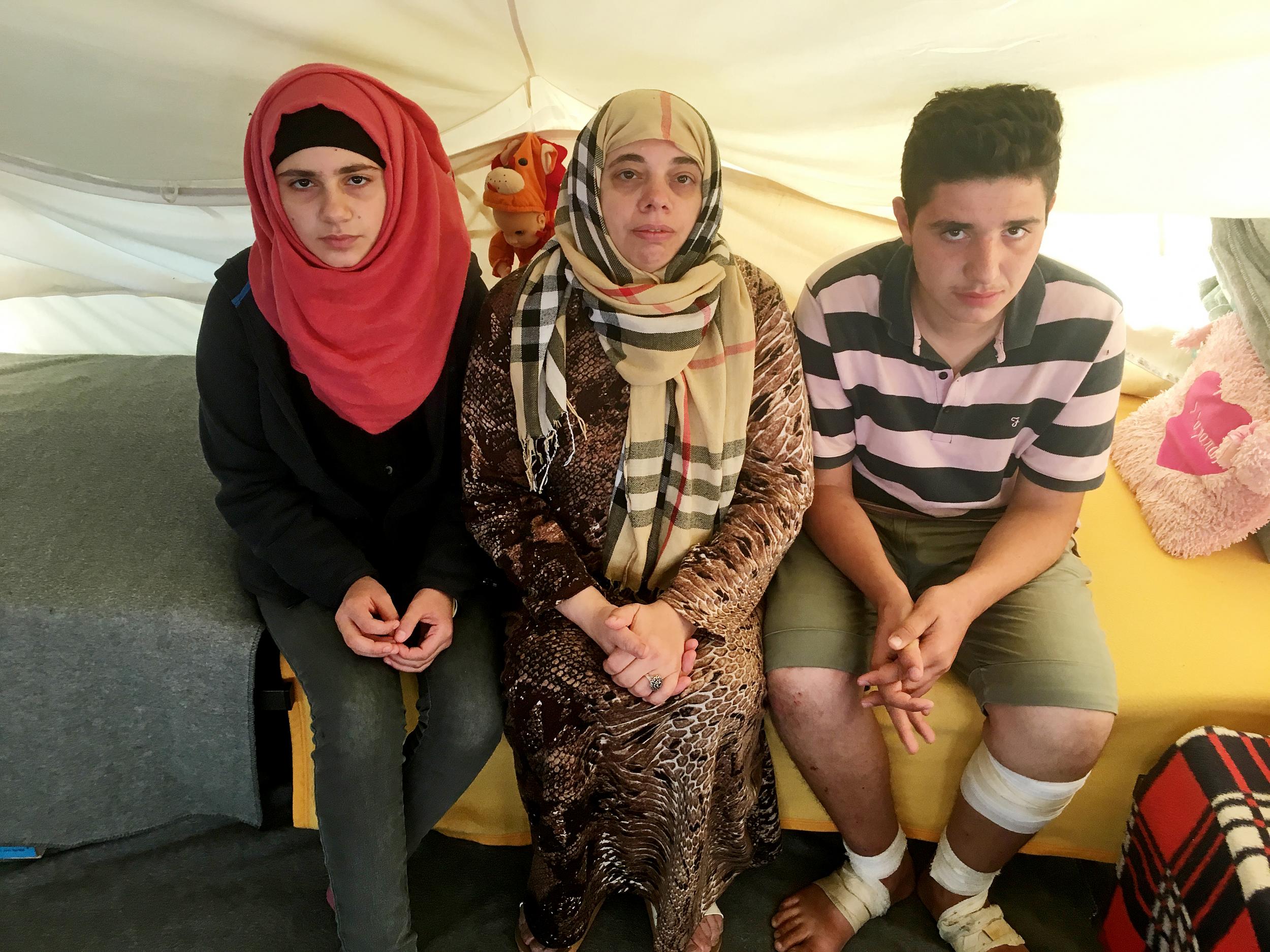 Lamis Wahed, 48, centre, sits with two of her four children, Rama, 16, left, and Kamal, 17. They have been stranded in Greece for seven months. They have applied for a programme to resettle them elsewhere in Europe. But as nations renege on their promises to take in refugees, they are still waiting