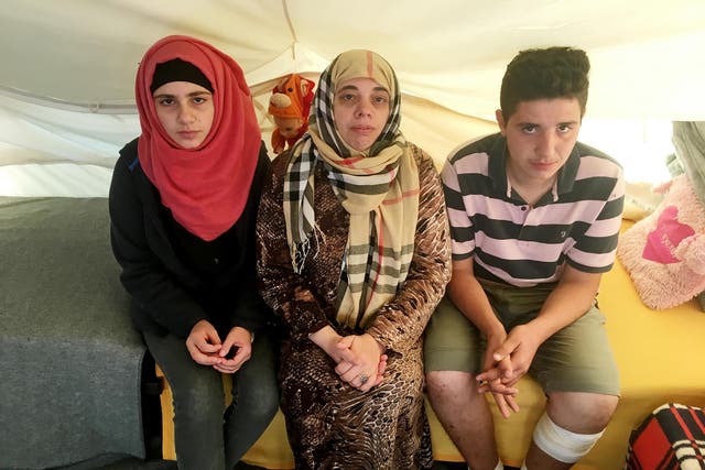 Lamis Wahed, 48, centre, sits with two of her four children, Rama, 16, left, and Kamal, 17. They have been stranded in Greece for seven months. They have applied for a programme to resettle them elsewhere in Europe. But as nations renege on their promises to take in refugees, they are still waiting