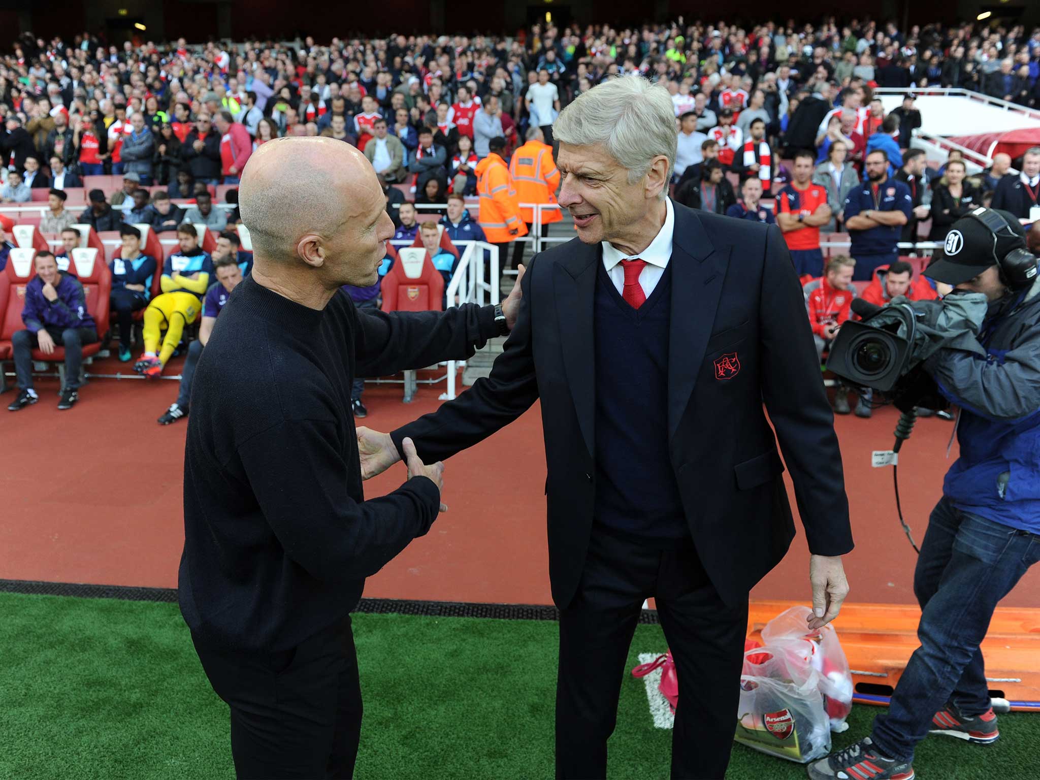 Bob Bradley is greeted by Arsene Wenger on the side-lines