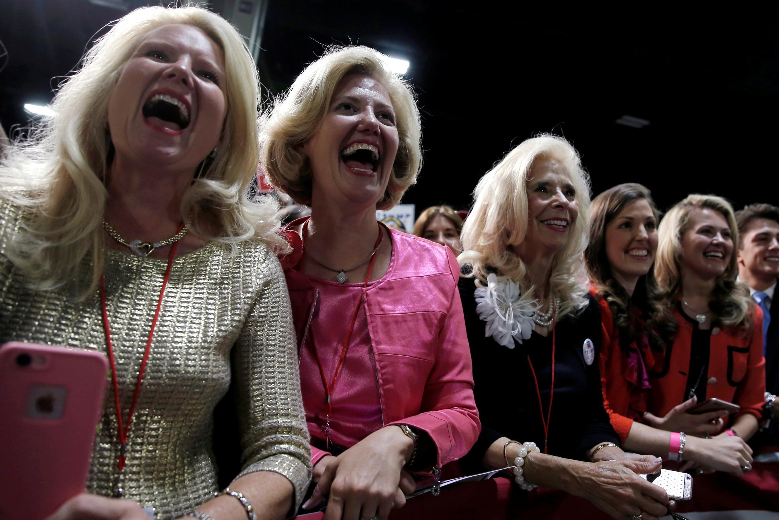 Supporters of Republican US presidential nominee Donald Trump cheer as he takes the stage at a campaign rally in Charlotte, North Carolina