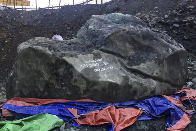 A man sits on giant jade stone at a mine in Phakant, Kachin State, northern Burma