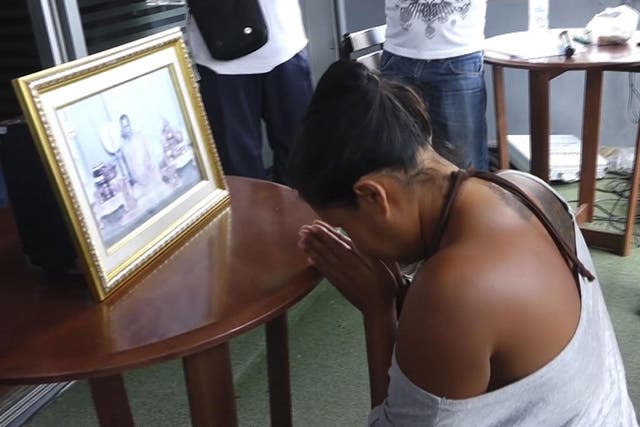 Umaporn Sarasat pays her respects in front of a portrait of King Bhumibol Adulyadej in Koh Samui