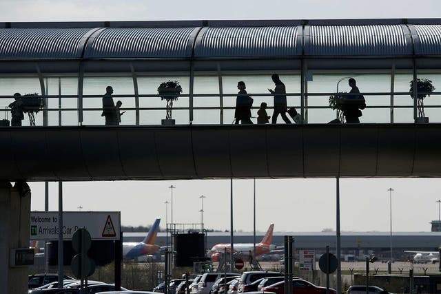 Passengers make their way through a terminal building at Manchester Airport