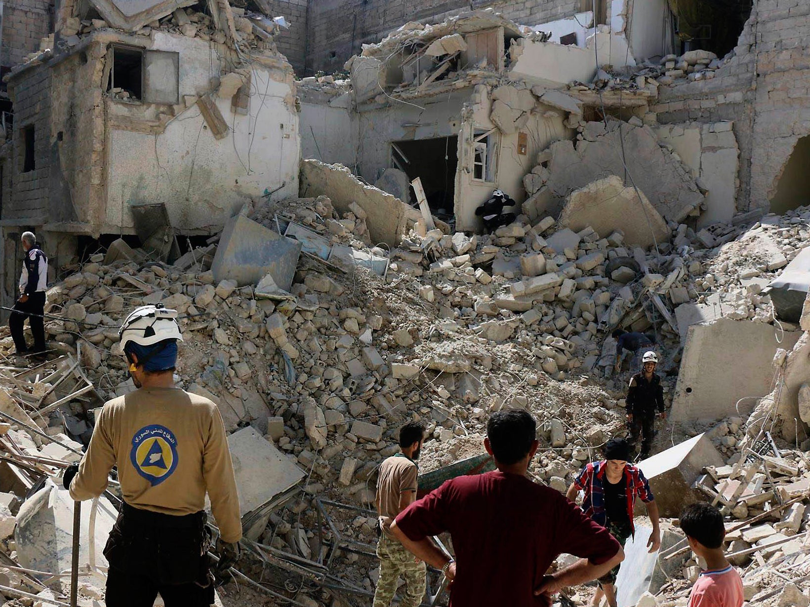 Syrian Civil Defense workers search through the rubble in rebel-held eastern Aleppo, Syria