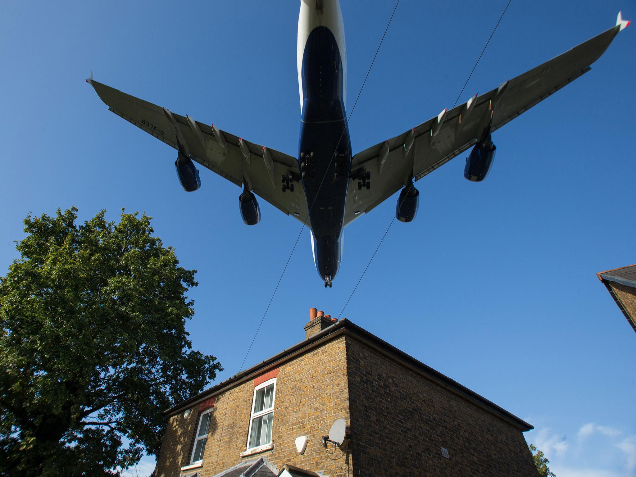 A plane flies over a house near Heathrow Airport