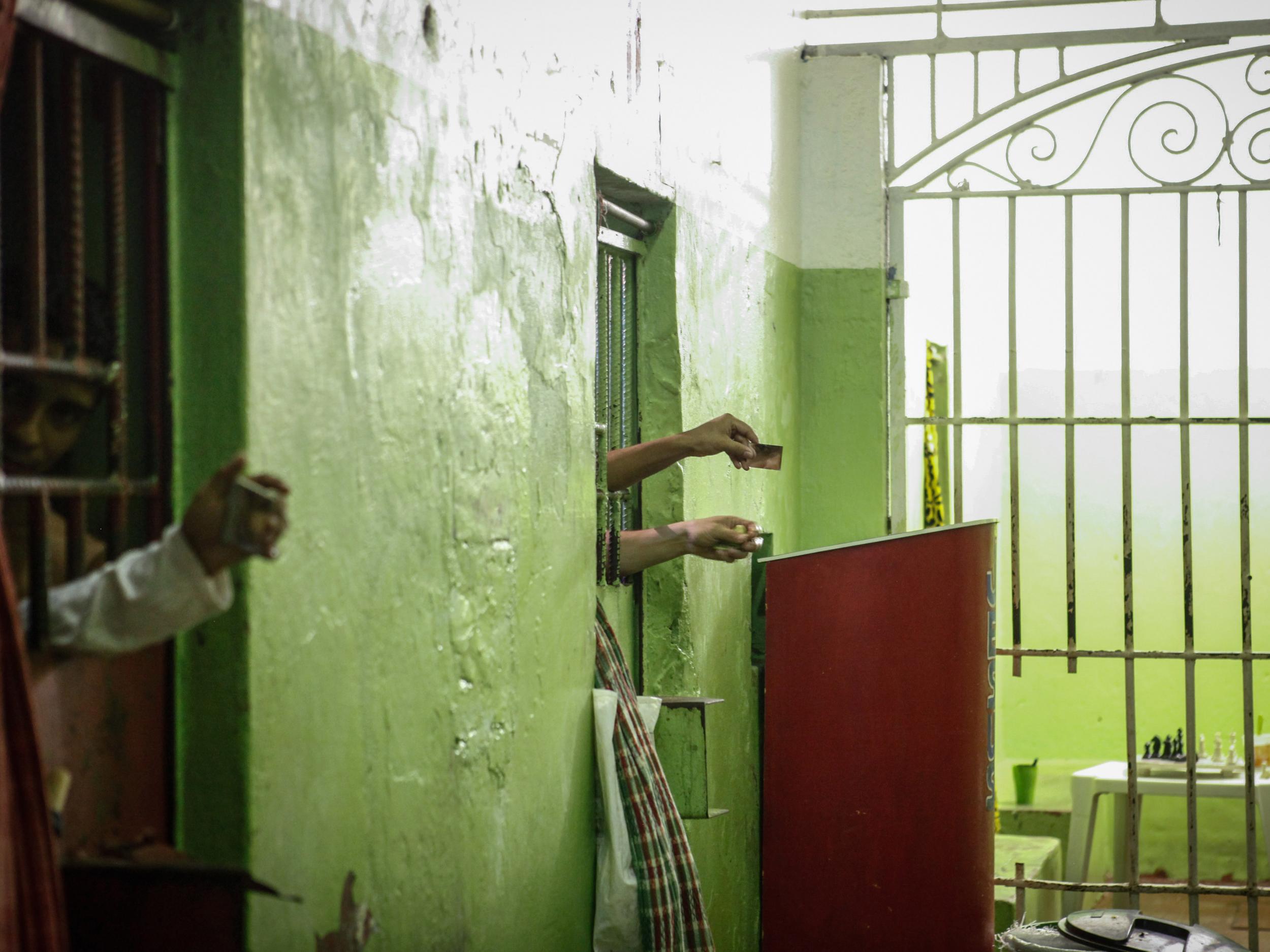Inmates use mirrors to view visitors from their cells in a Brazil prison