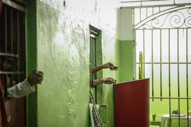 Inmates use mirrors to view visitors from their cells in a Brazil prison