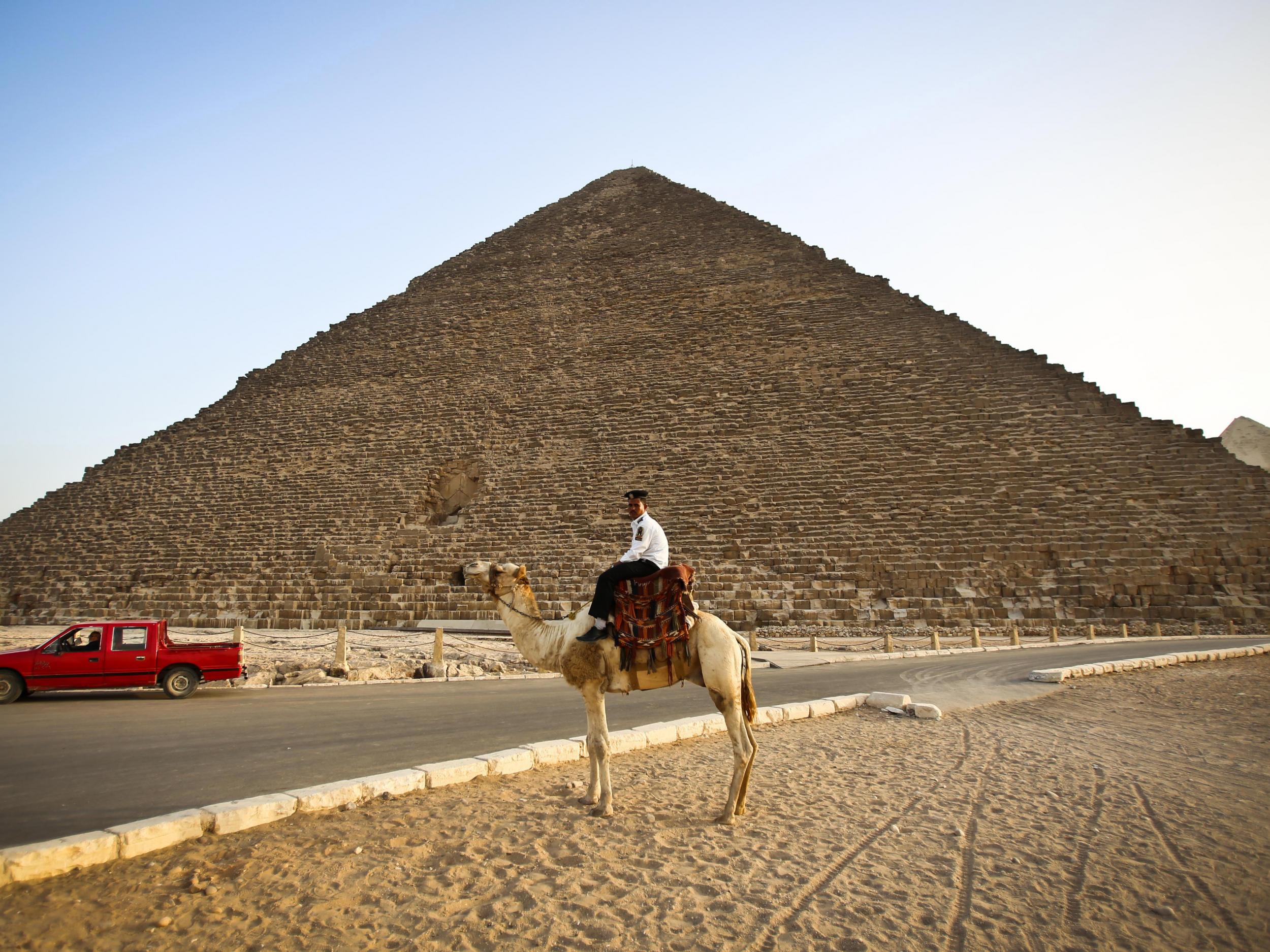 A police officer riding a camel past the pyramid of Menkaure in Giza, on the outskirts of Cairo