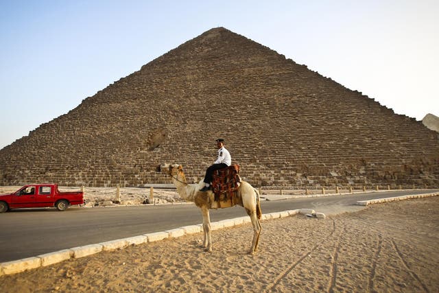 A police officer riding a camel past the pyramid of Menkaure in Giza, on the outskirts of Cairo