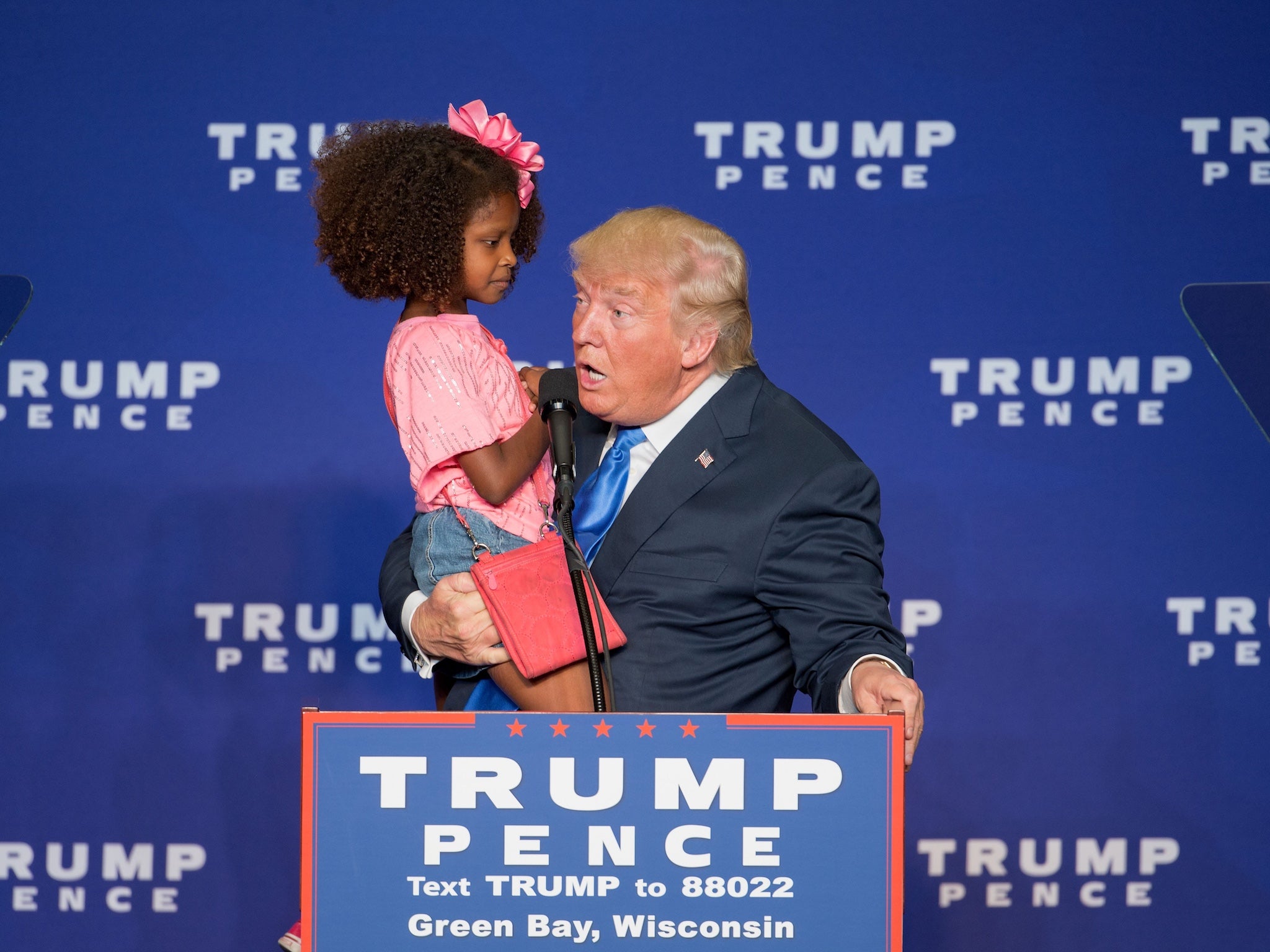 Republican presidential nominee Donald Trump holds a child as he speaks during a rally at the KI Convention Center on October 17, 2016 in Green Bay, Wisconsin