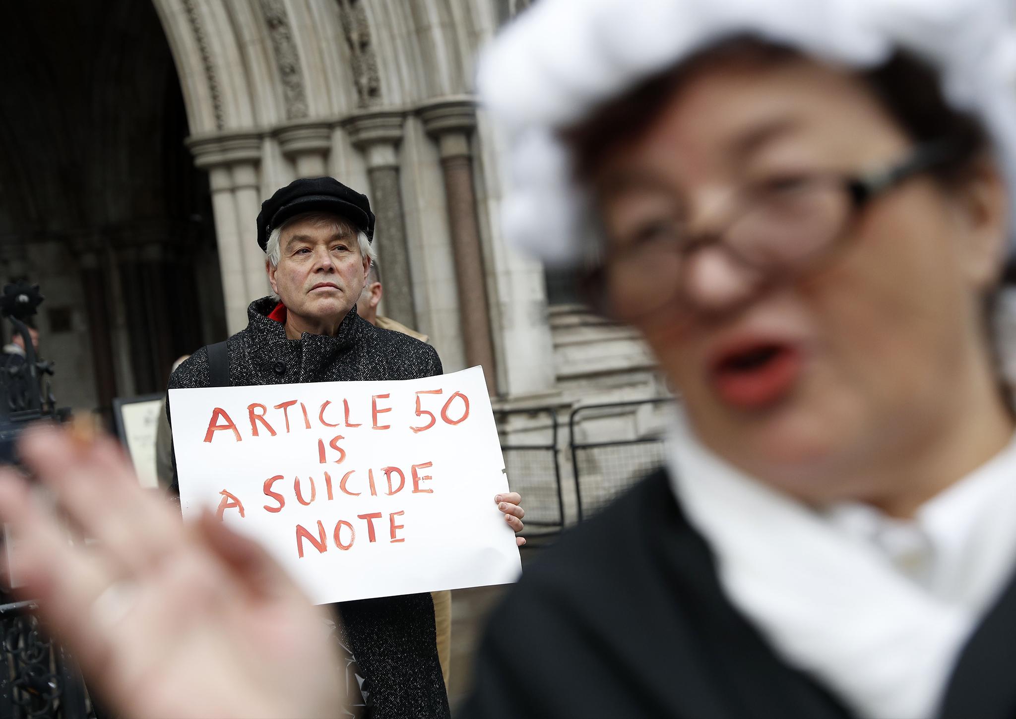 A pro-Brexit supporter (R) from Invoke Article 50 Now!, dressed as a judge, stands in front of a Pro-European Union supporter outside the entrance to The Royal Courts of Justice, Britain's High Court, in London on October 13, 2016