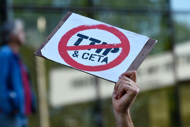 A man holds a placard at an anti-CETA/TTIP protest