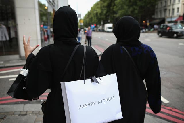 Two muslim women wearing black abayas and headscarves walk through Knightsbridge, another popular shopping area in London