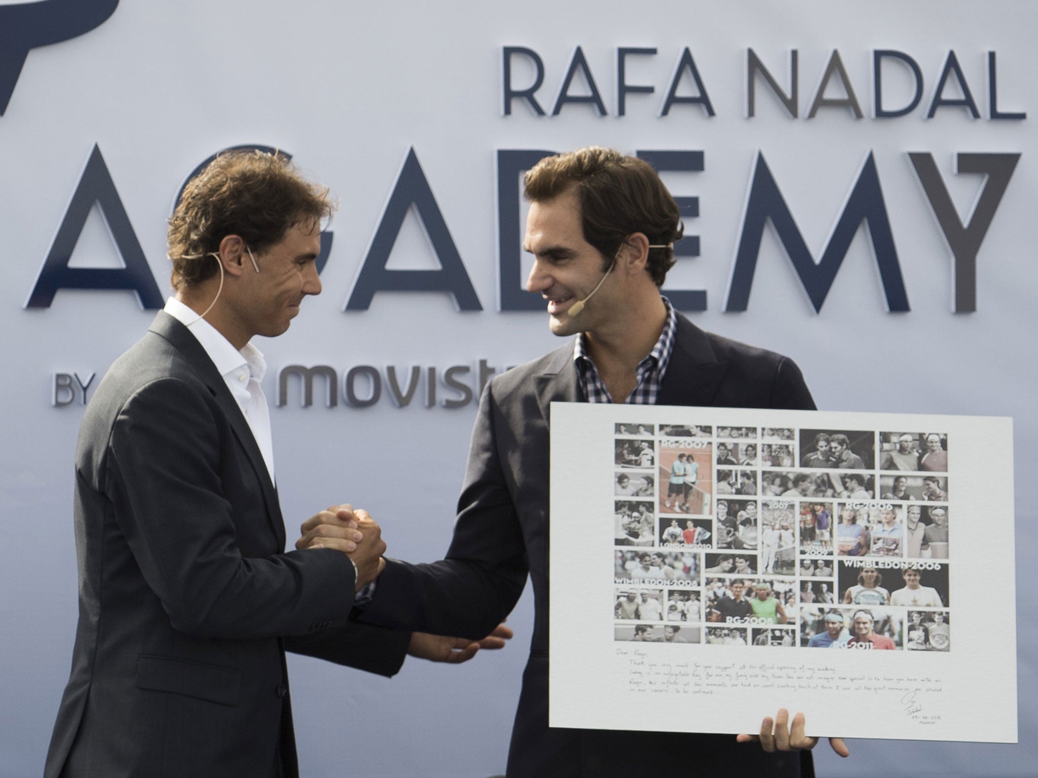 Rafa Nadal presents Roger Federer with a framed picture of their many duels down the years at the opening of his academy on Thursday