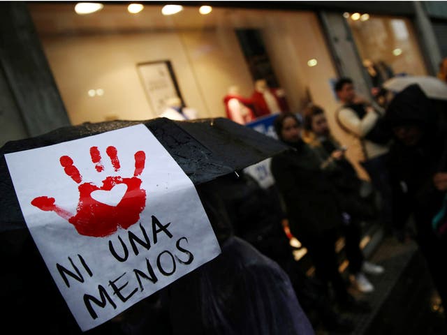 A woman carries a sign that reads "Not another (woman) less" on her umbrella during a demonstration in Buenos Aires
