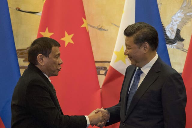 Mr Duterte, left and Chinese president Xi Jinping shake hands during the Beijing visit