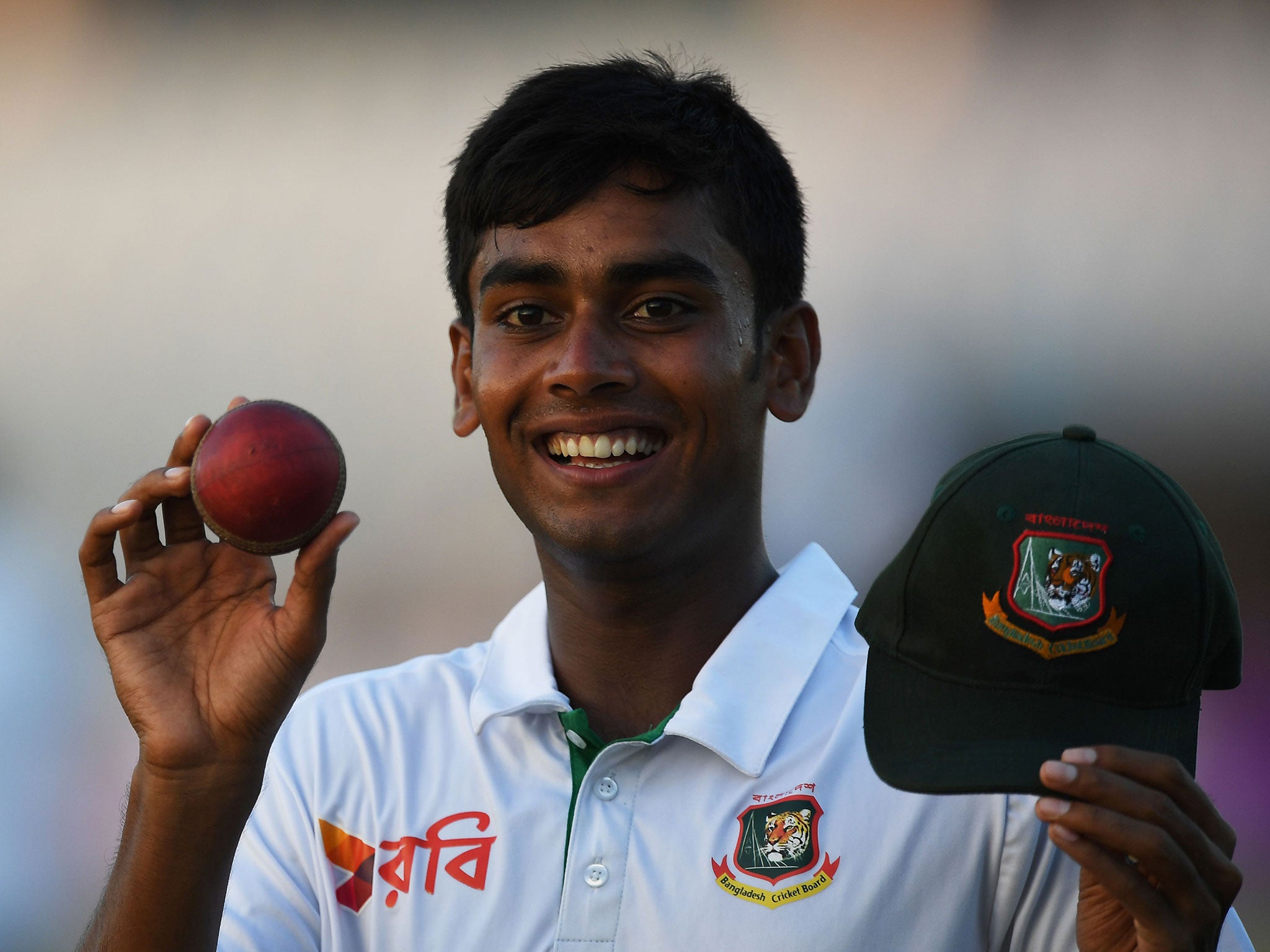 Bangladesh's Mehedi Hasan poses with the match ball after his five wicket haul as he returns to the locker room after the first day of play in the first Test