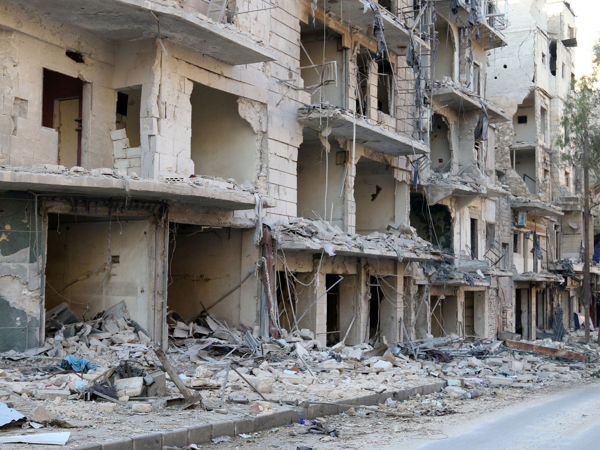 A man walks past damaged buildings in the rebel held besieged al-Sukkari neighbourhood of Aleppo