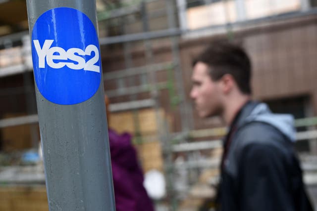 A pro-Scottish independence sticker is attached to a sign post on the Royal Mile in Edinburgh
