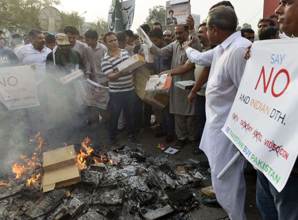Pakistani shopkeepers and traders burn Indian products including TV transmission systems and CDs during a demonstration in Lahore on October 8, 2016