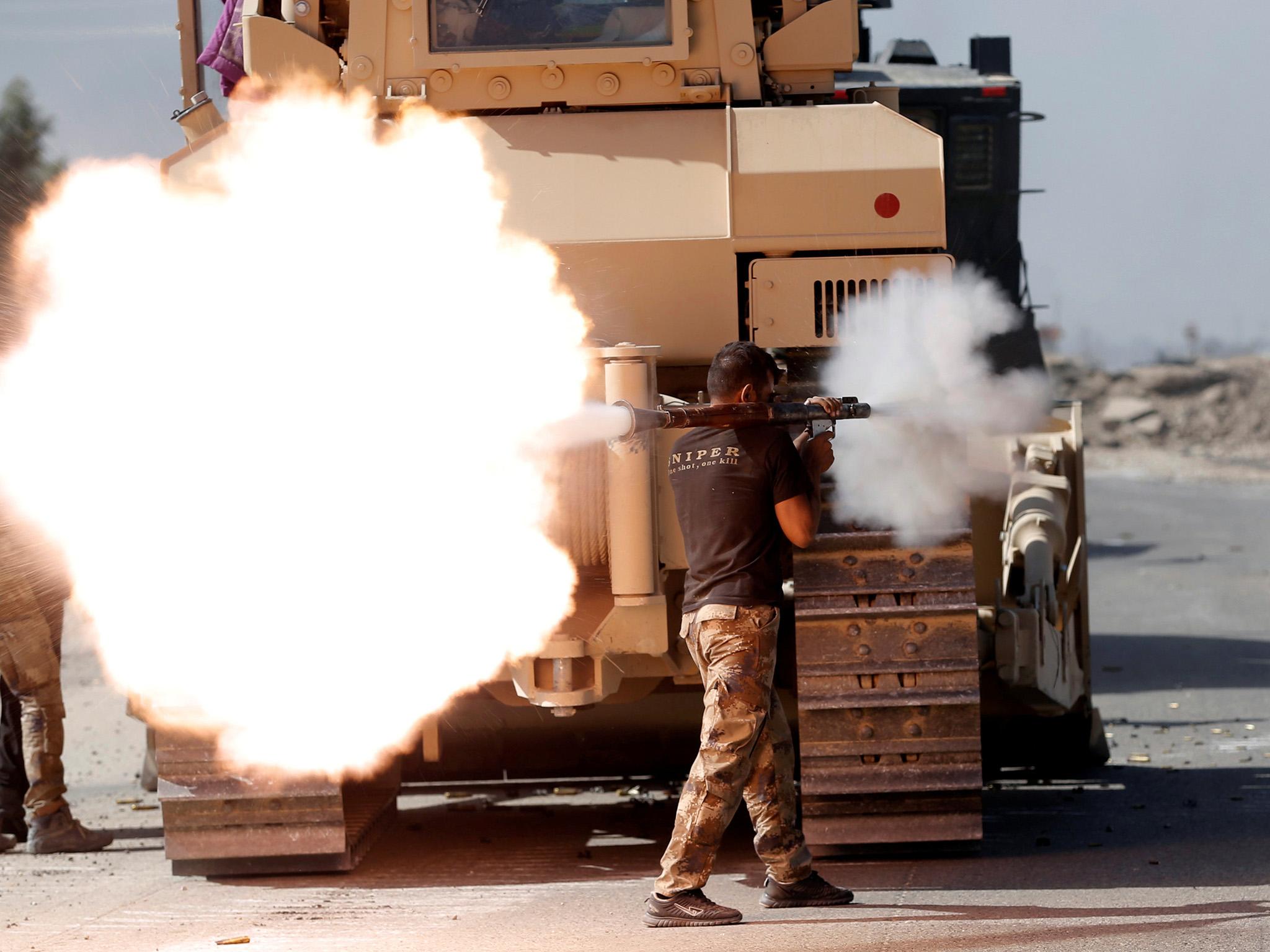 An Iraqi special forces soldier fires an RPG during clashes with Isis fighters in Bartella, east of Mosul