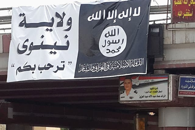 A flag belonging to the Islamic State in Iraq and the Levant (ISIL) along a street in the city of Mosul