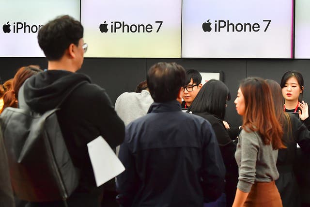 People wait in line to buy new iPhone models at a telecom shop in Seoul, South Korea