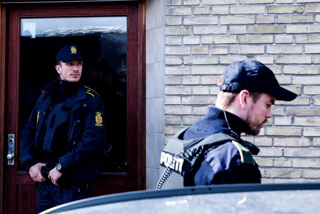 Policemen stand in front of a house in Copenhagen, Denmark