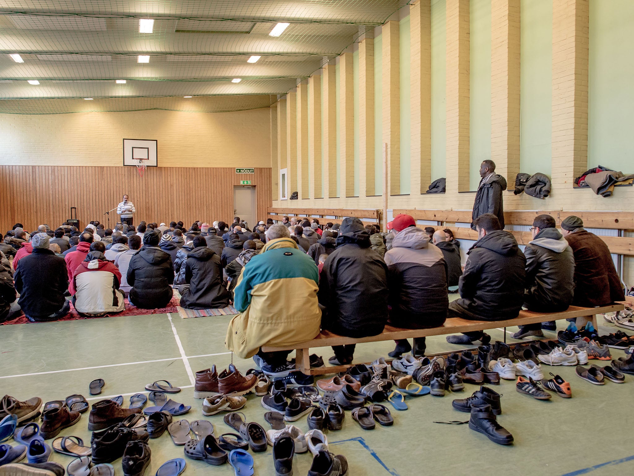 Refugees praying in a gym at Sweden's largest temporary camp for refugees at a former psychiatric hospital in Vanersborg in the south of the country