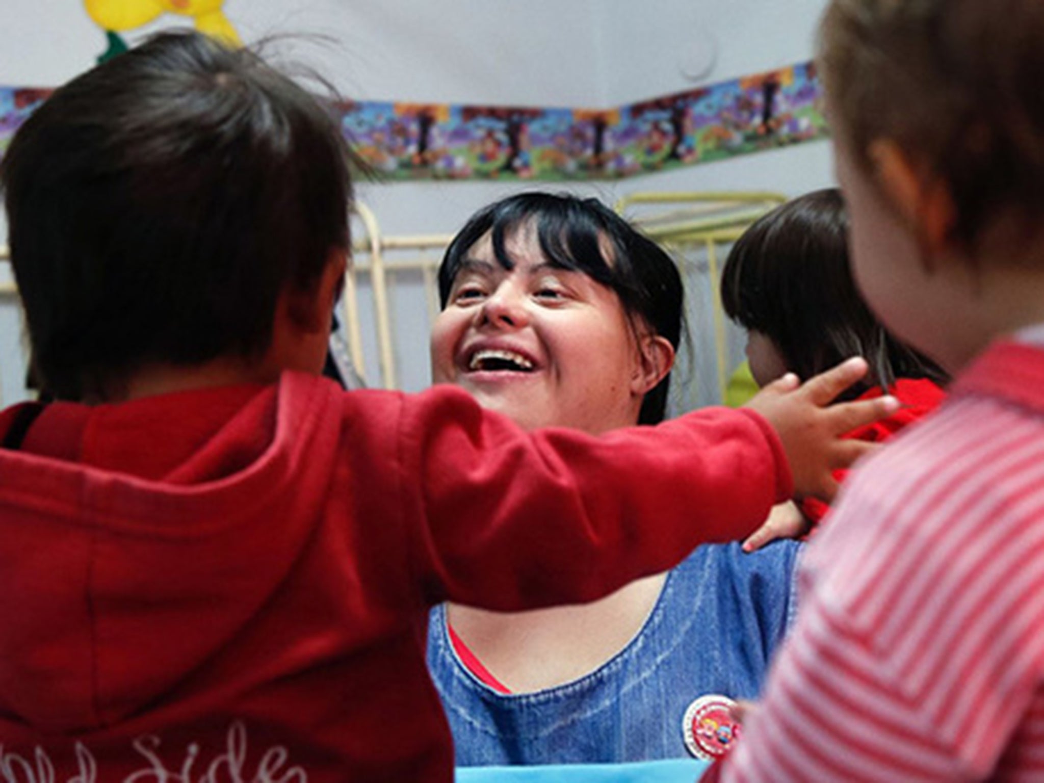 Noelia Garella, a nursery school teacher born with Down syndrome, plays with children at the Jeromito kindergarten in Cordoba, Argentina