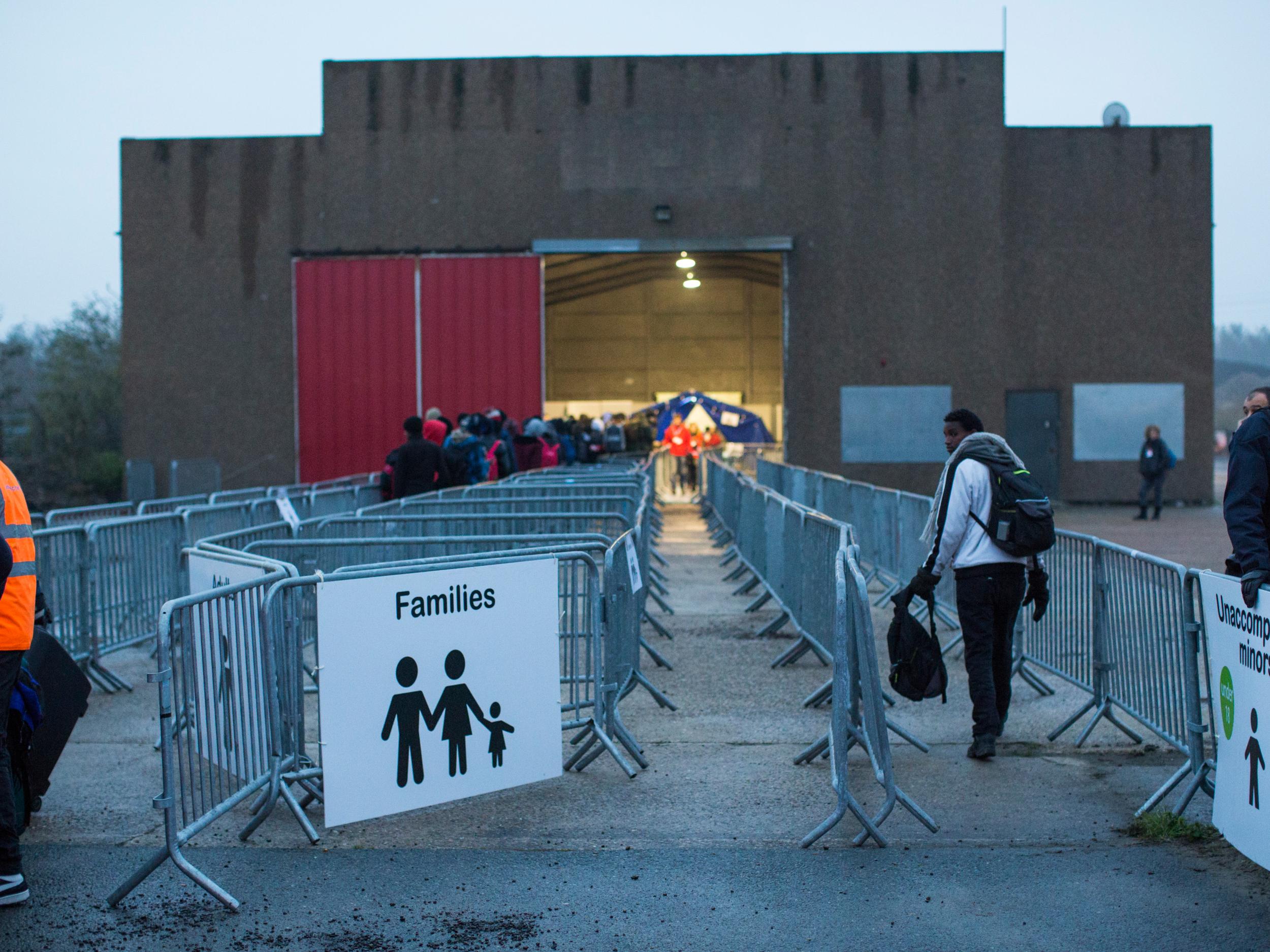 An unaccompanied minor enters a reception point outside the Jungle migrant camp as migrants are processed before boarding buses to refugee centres around France