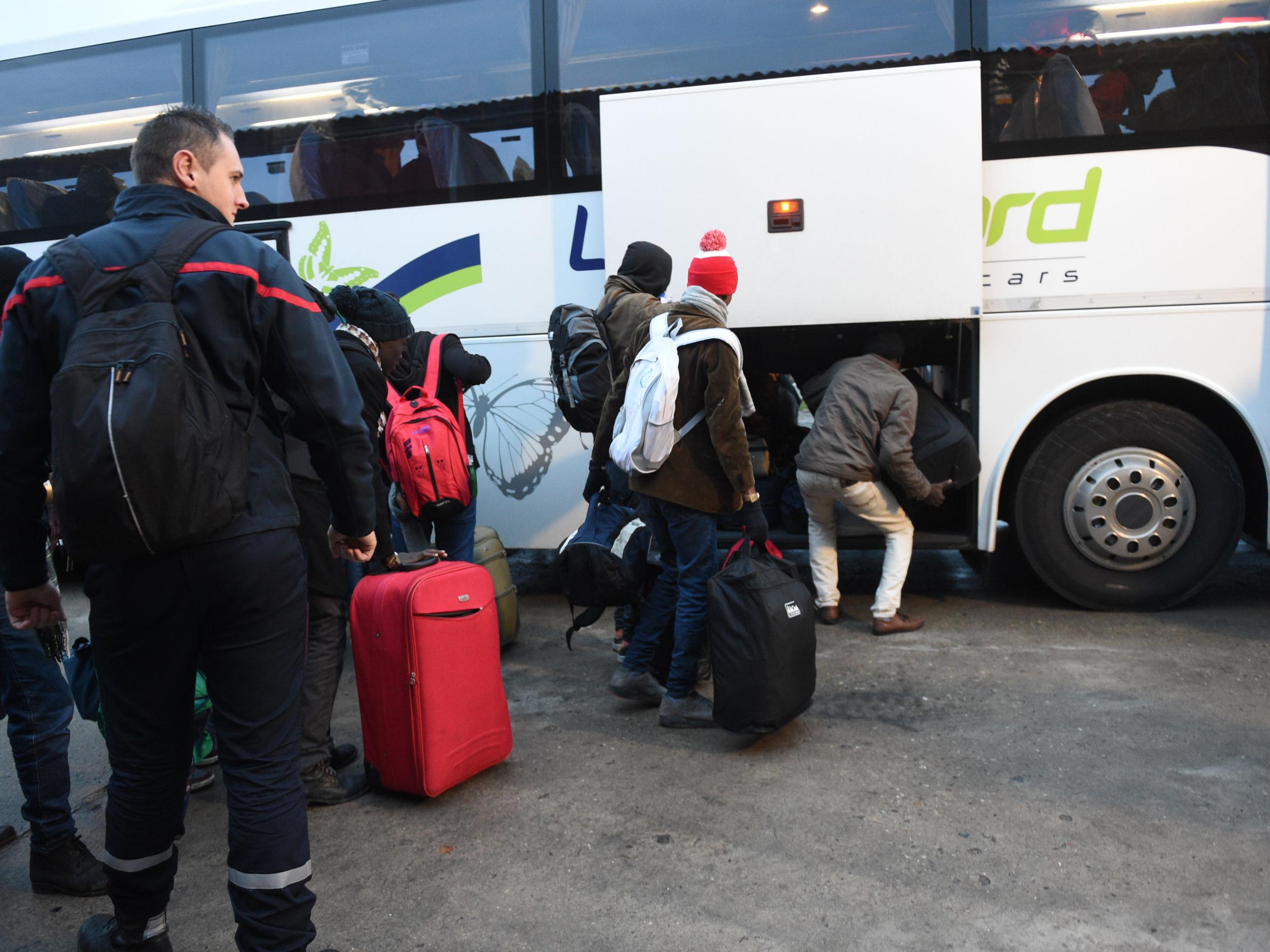 Migrants board buses for transportation to reception centres across France (Getty Images )