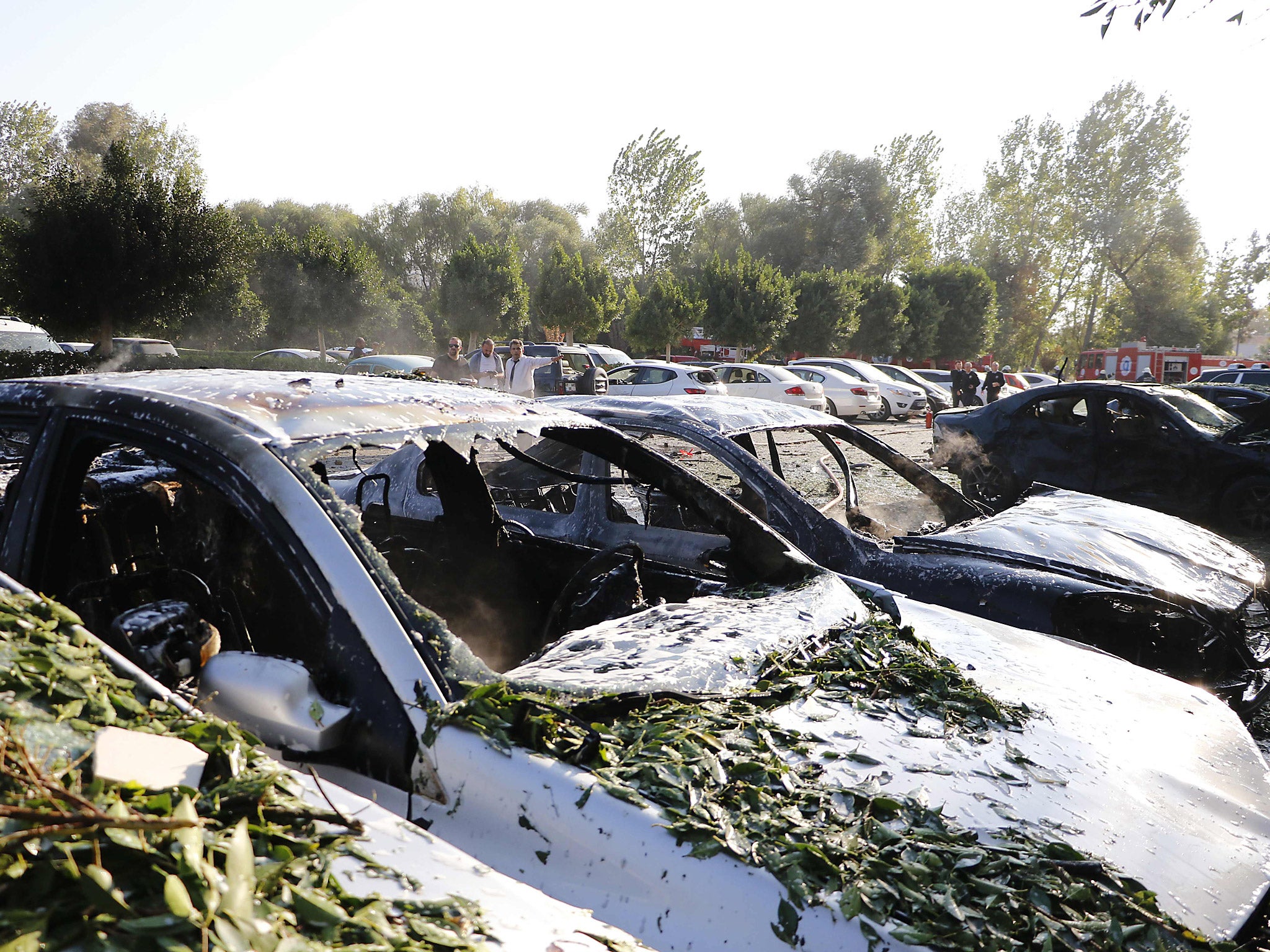 People stand by damaged cars near the site of an explosion in Antalya