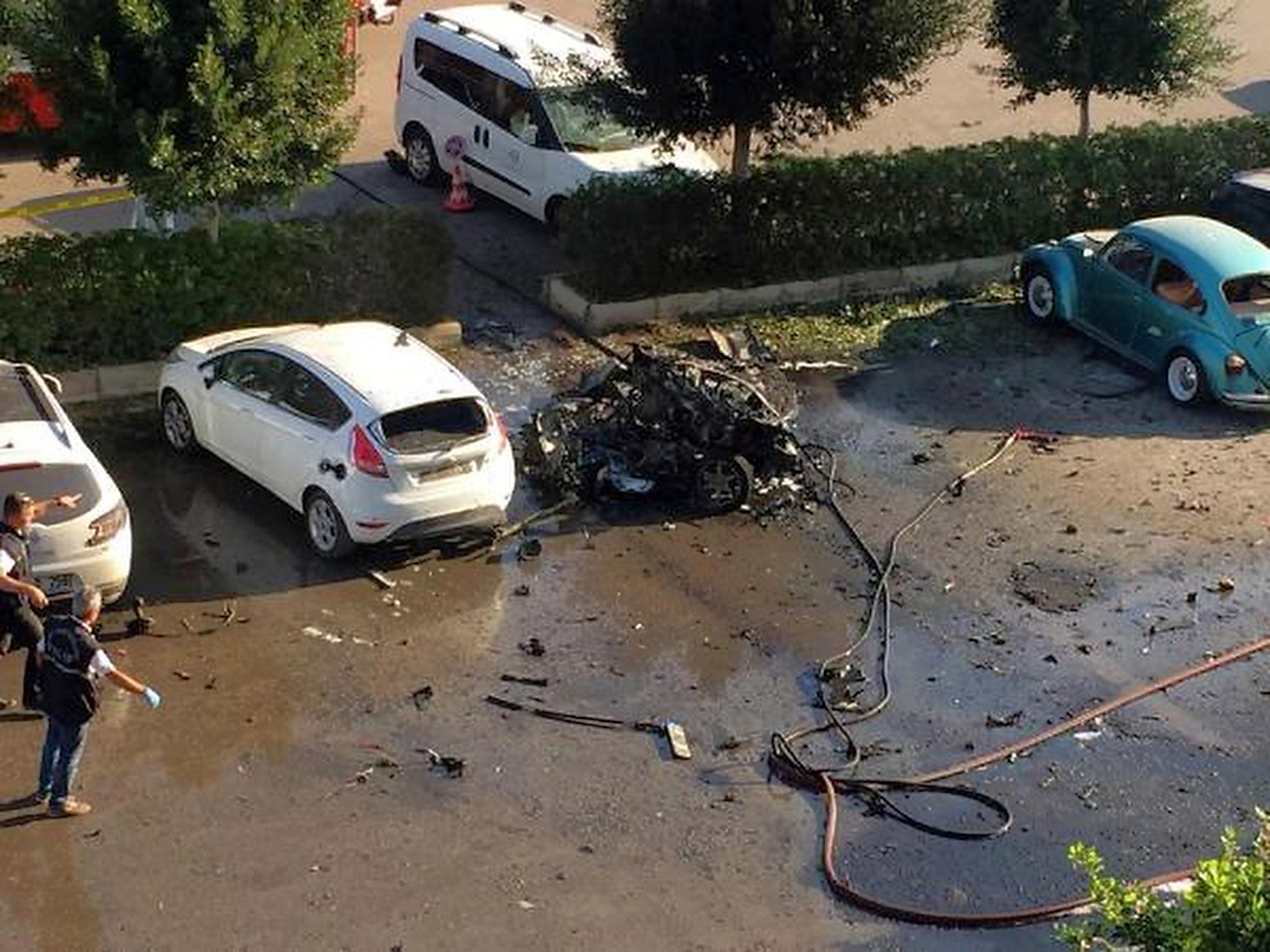 Officials investigate the site after an explosion in Turkey's Mediterranean resort of Antalya. The explosion of a car in the parking lot of the local chamber of trade on lightly injured about a dozen people