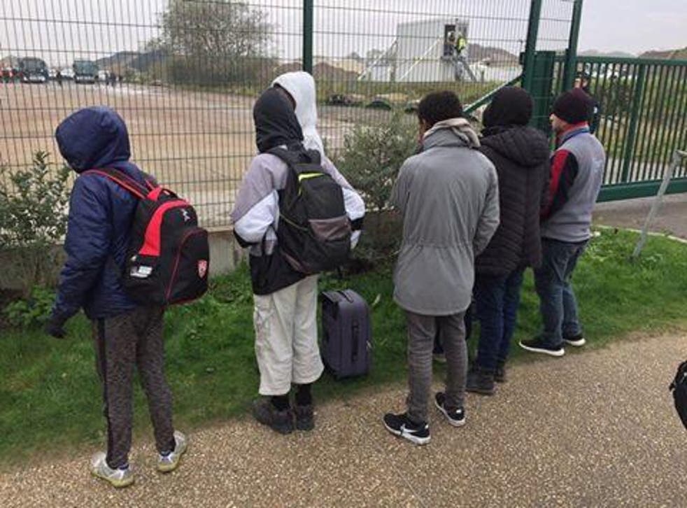Six of the children, aged 13 and under, stand with their packed bags in Calais waiting for the bus that will transport them to the UK