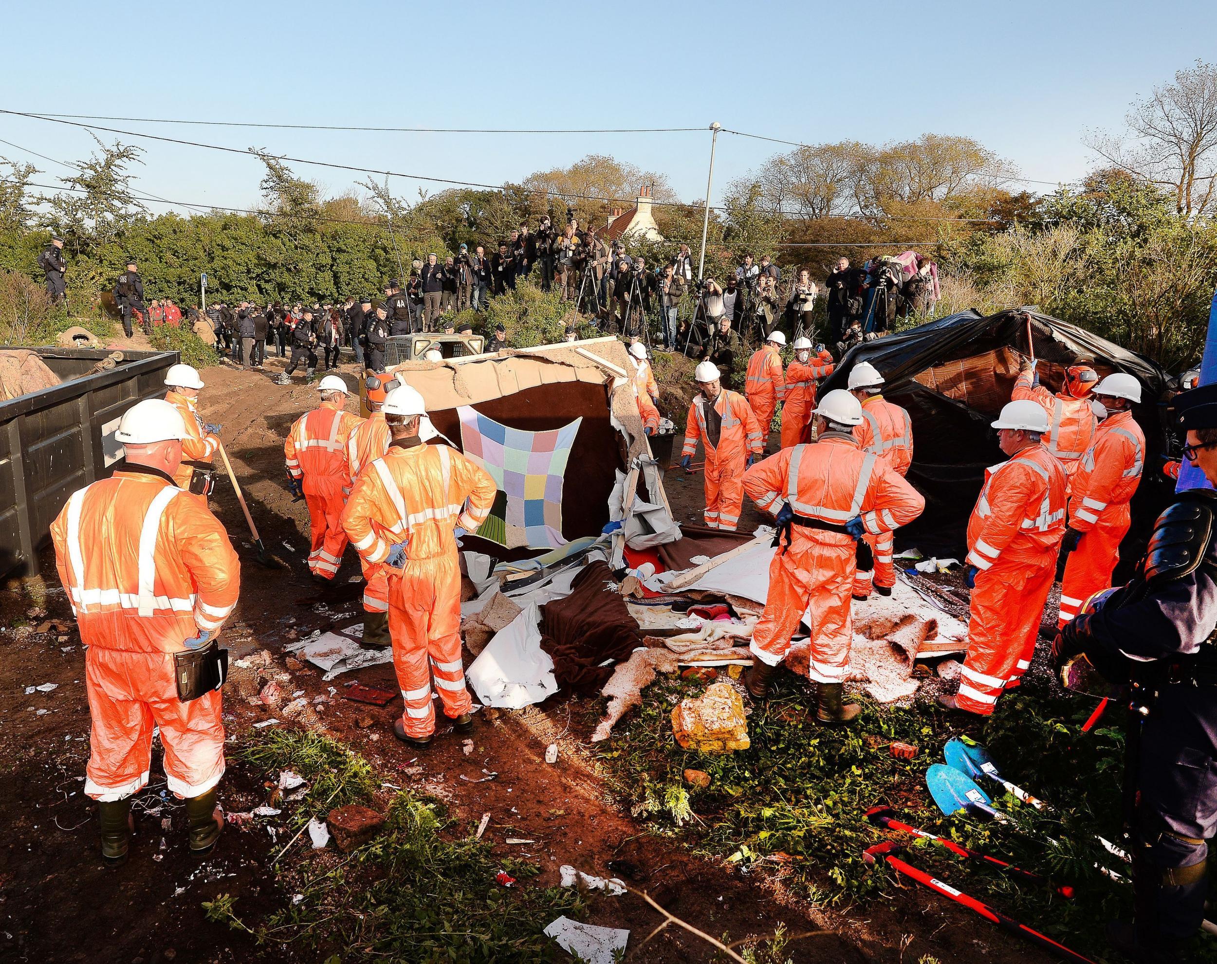 The demolition began as a team of workmen and riot police began dismantling empty tents