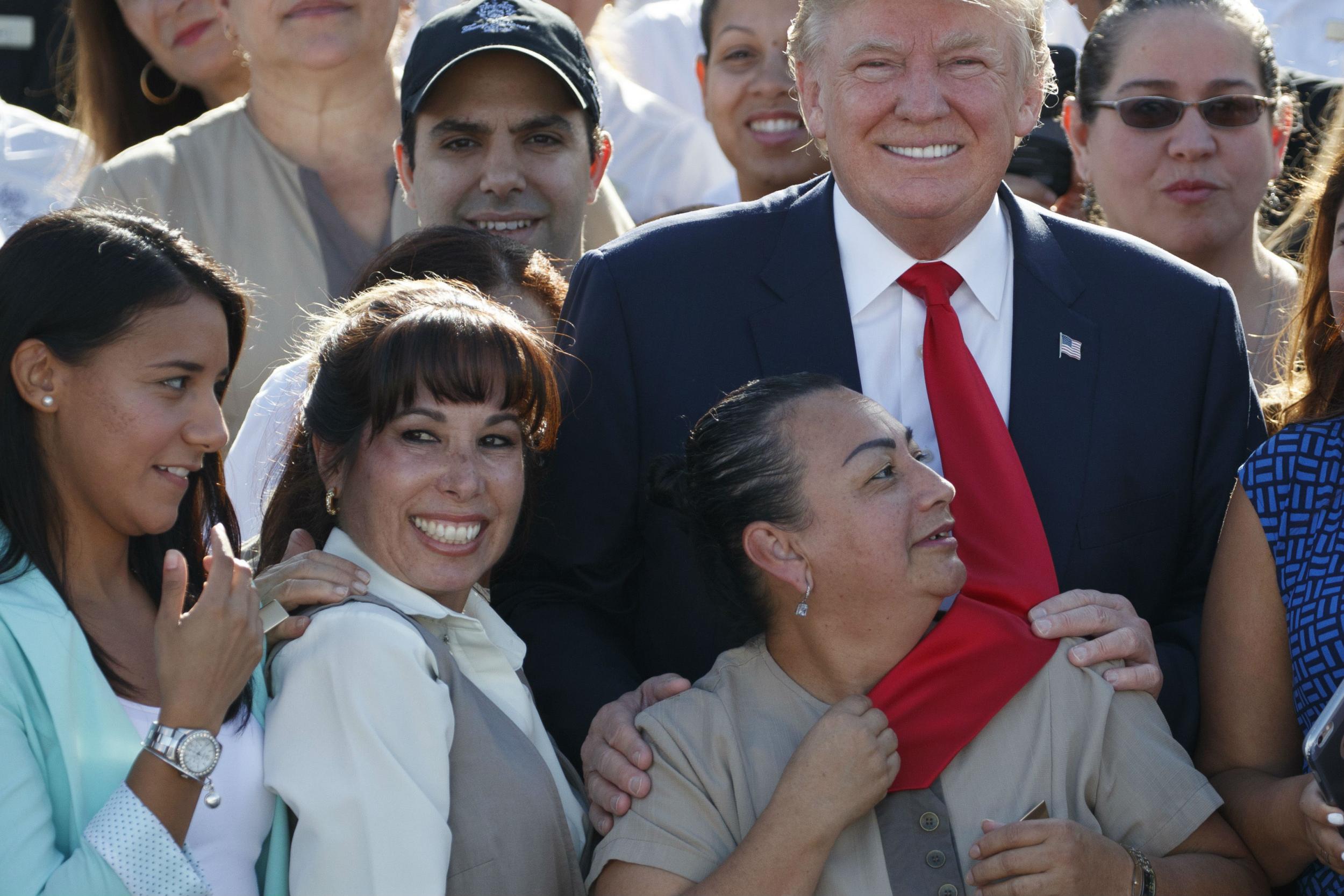 An adoring employee grabs Trump's tie on Tuesday at his Doral golf club in Florida