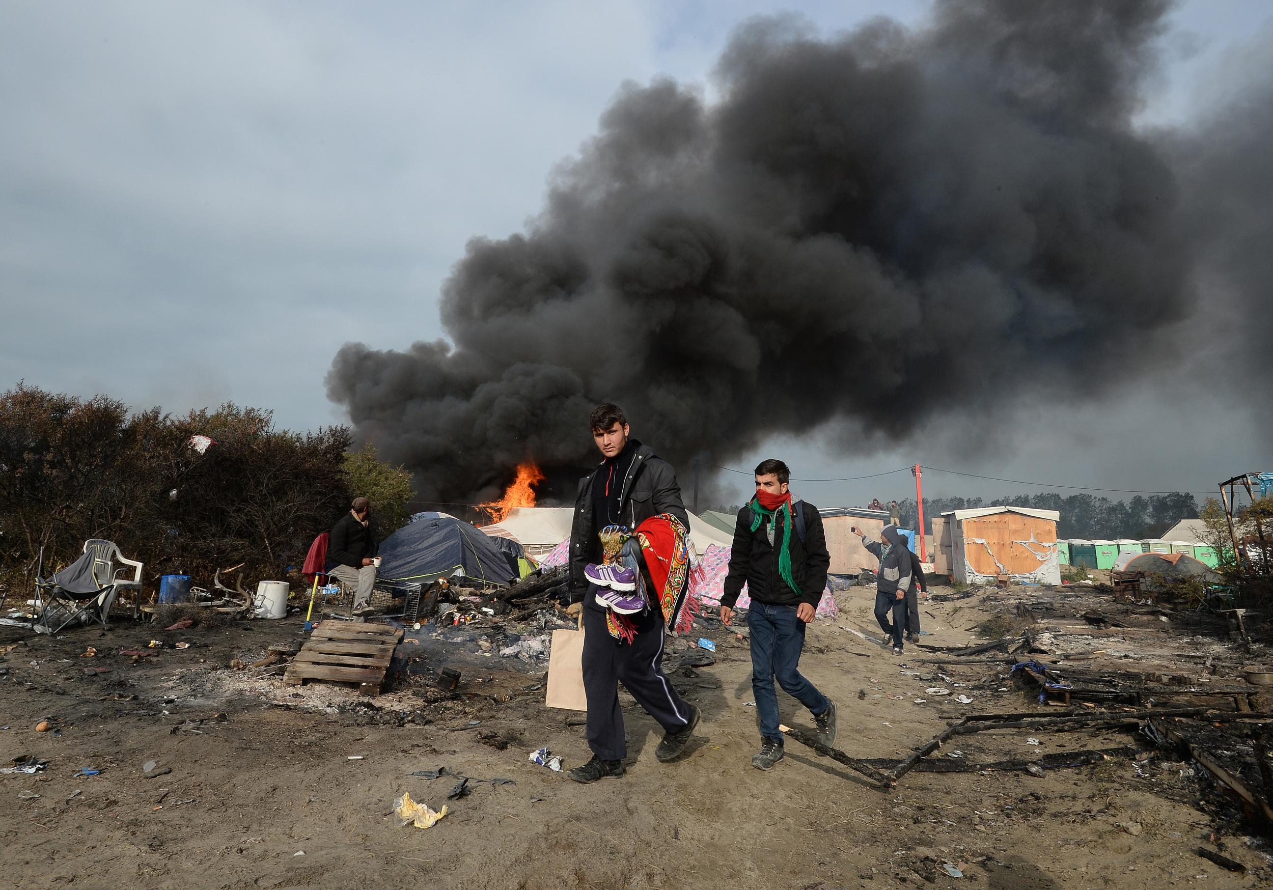 Smoke rises over the Calais Jungle camp, as several large fires broke out in the near deserted migrant camp in northern France on the third day of the operation to clear it.