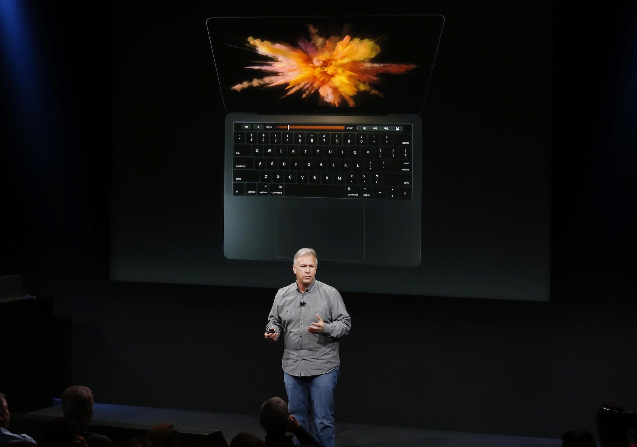 Phil Schiller, senior vice president of worldwide marketing at Apple, speaks under a graphic of a new MacBook Pro during an Apple media event in Cupertino, California, U.S. October 27, 2016