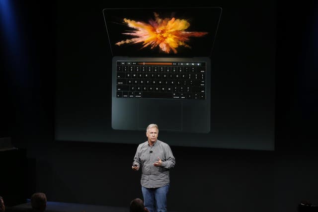 Phil Schiller, senior vice president of worldwide marketing at Apple, speaks under a graphic of a new MacBook Pro during an Apple media event in Cupertino, California, U.S. October 27, 2016