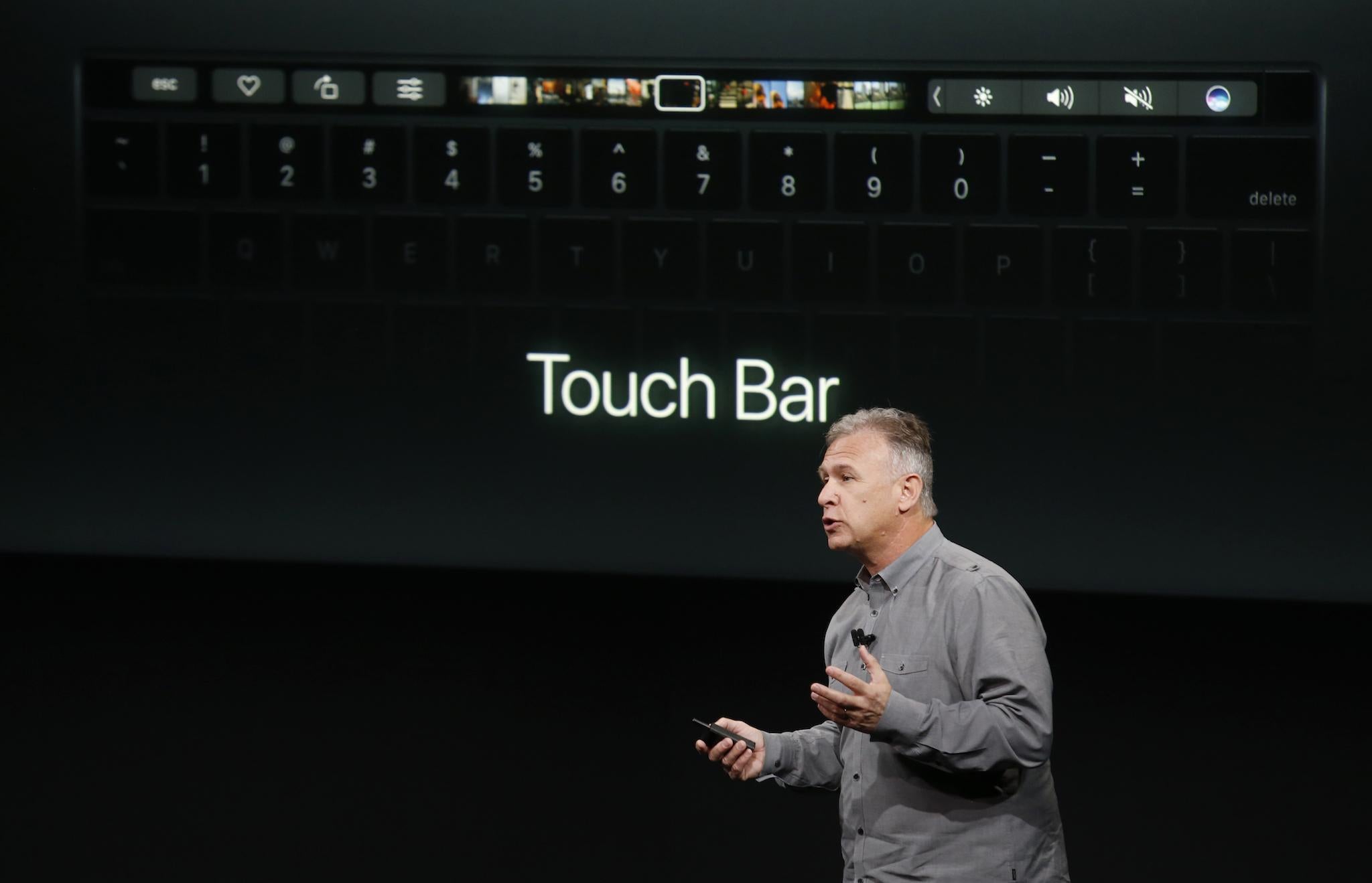 Phil Schiller, senior vice president of worldwide marketing at Apple, speaks under a graphic of the touchbar of a new MacBook Pro during an Apple media event in Cupertino, California, U.S. October 27, 2016