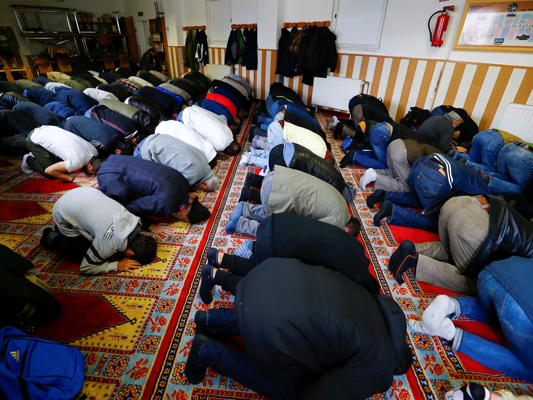 Muslims bow their heads during Friday prayers at the Turkish Kuba Camii mosque