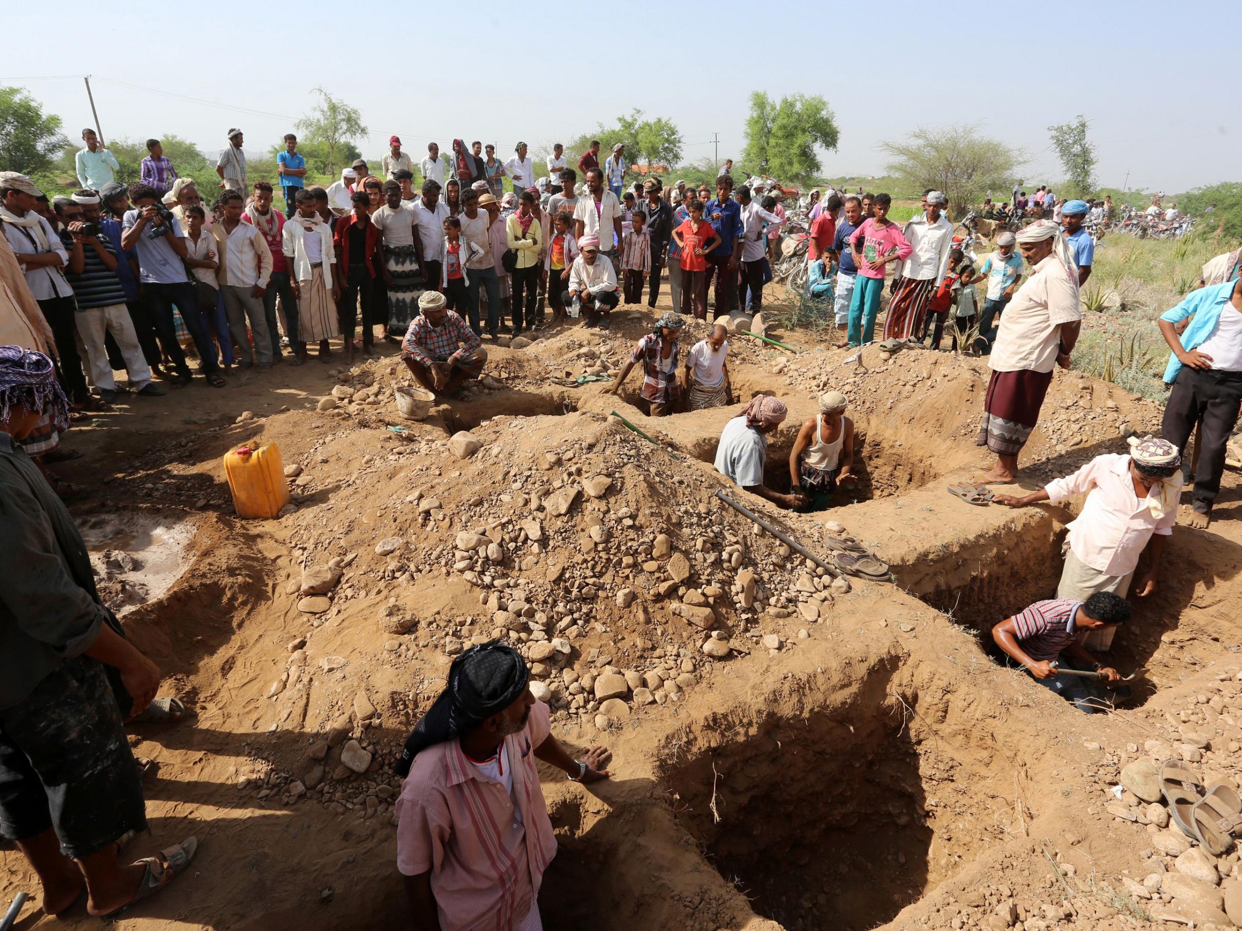 Yemenis burying family members in Bajil, the day after a reported air strike by the Saudi-led coalition in October