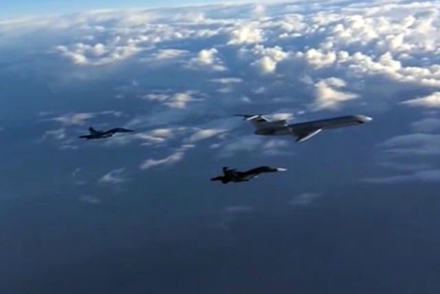 An image taken from a footage made available on the Russian Defence Ministry's official website on 15 March, 2016, reportedly showing Russian Su-34 bombers and a Tupolev Tu-154 transport plane flying above an unknown location on their way from the Hmeimim airbase in Syria to their permanent bases in the Russian Federation