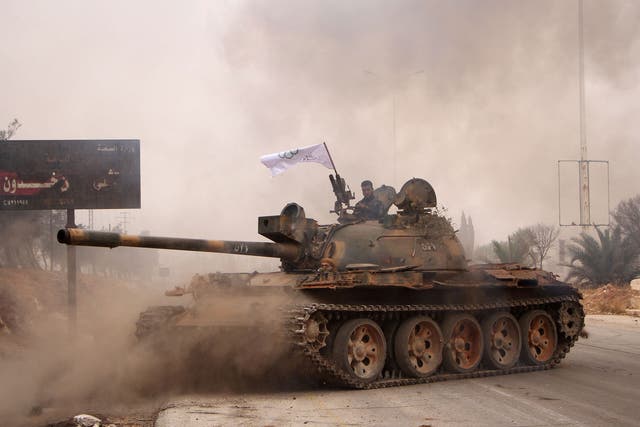 Rebel fighters from Jaish al-Fatah manoeuver a T-55 tank they launch an offensive against government forces in western Aleppo on 28 October