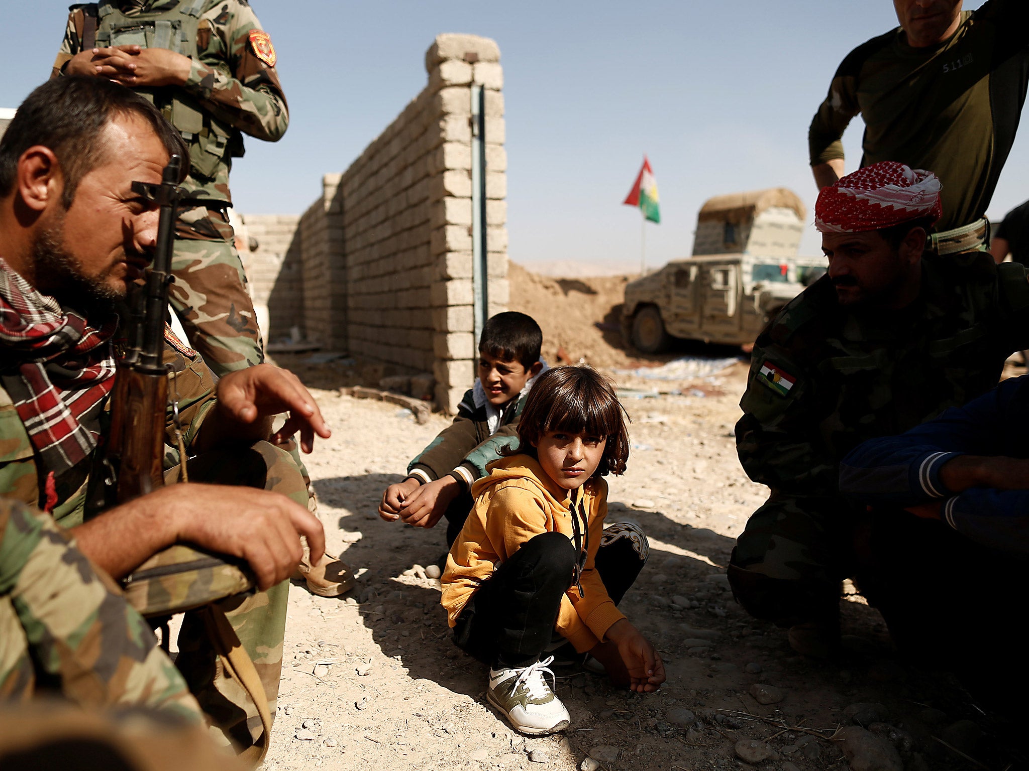 Children who just fled Abu Jarbuah village sit at a Kurdish Peshmerga position between two front lines near Bashiqa, east of Mosul, Iraq