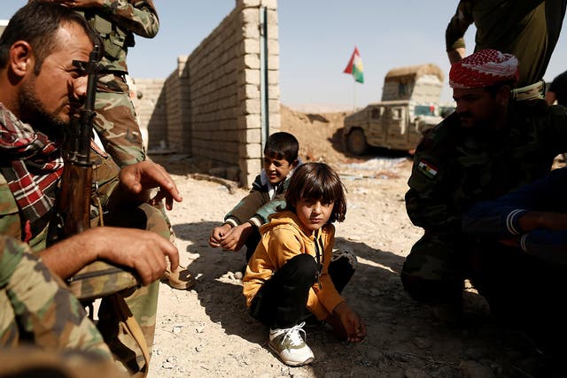 Children who just fled Abu Jarbuah village sit at a Kurdish Peshmerga position between two front lines near Bashiqa, east of Mosul, Iraq