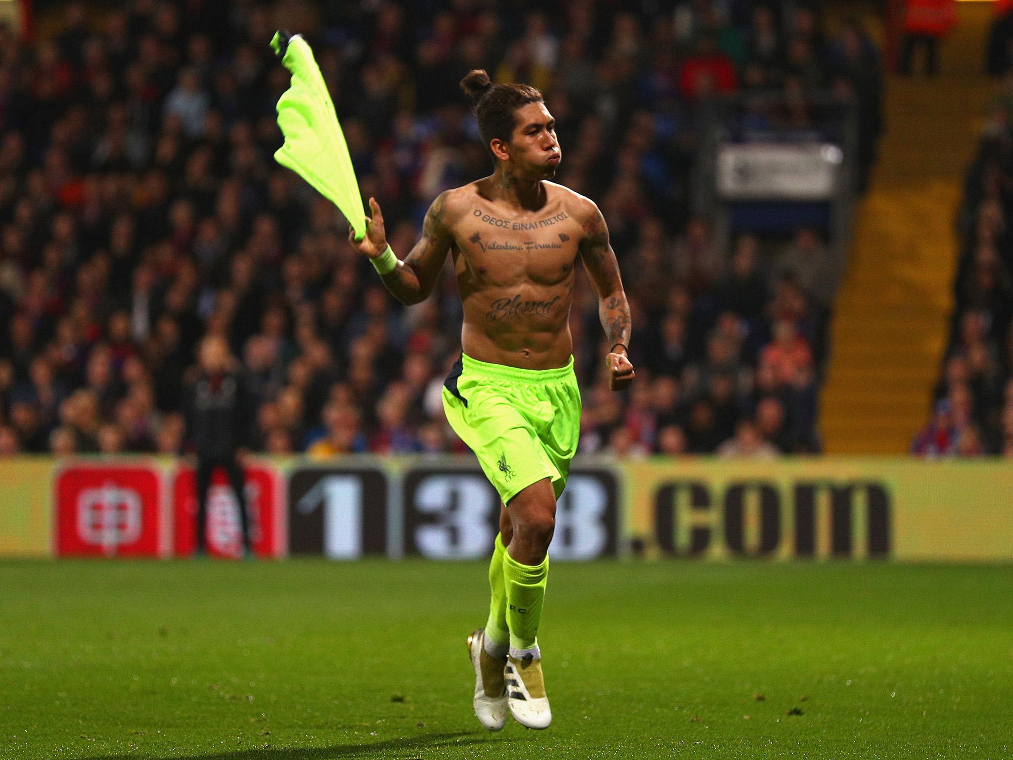 Roberto Firmino celebrates after chipping the ball over Crystal Palace goalkeeper Steve Mandanda to score the fourth goal