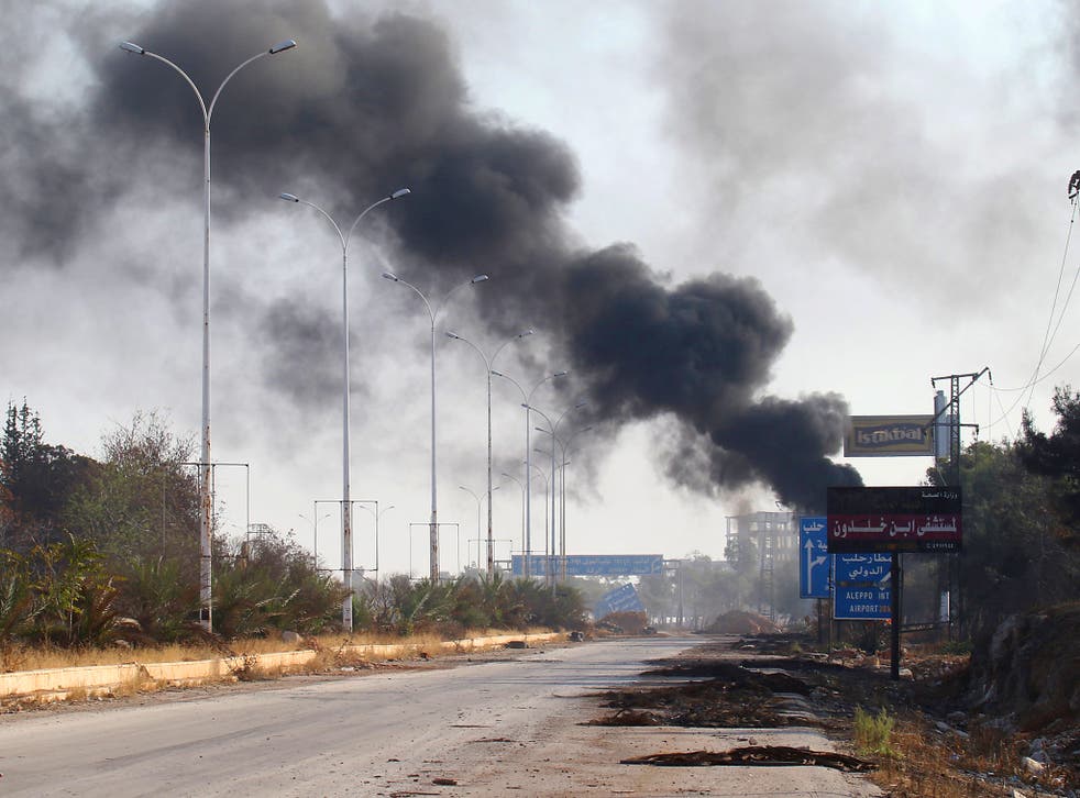 Smoke rises near a damaged road in Dahiyet al-Assad in Aleppo city, the scene of a recently defeated rebel counterattack